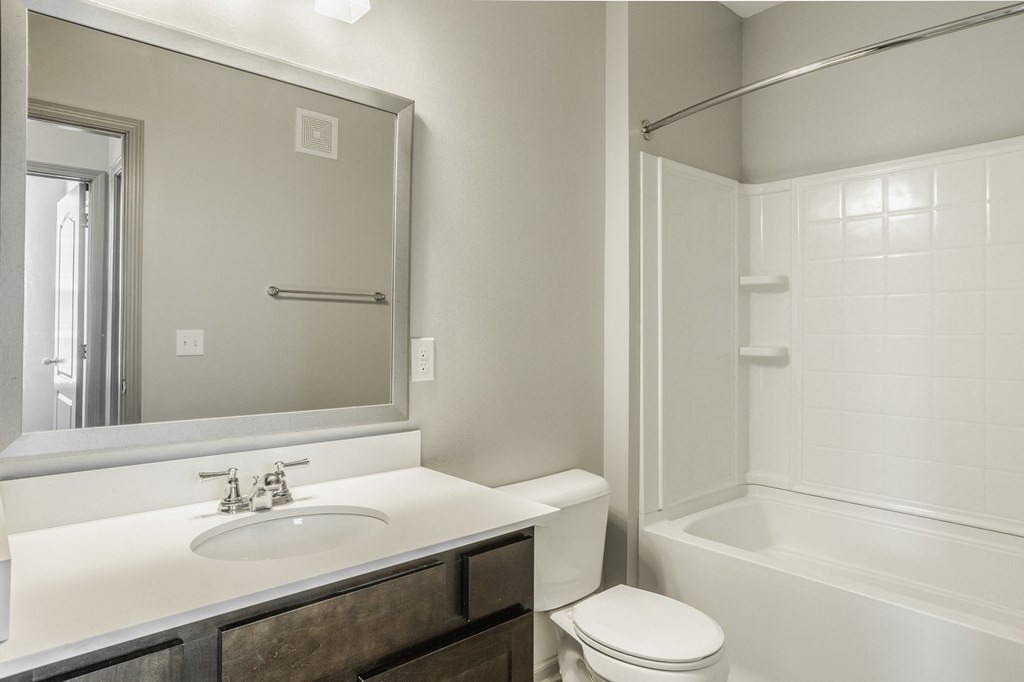 a bathroom with a sink toilet and shower and a mirror at The Avenue at Polaris Apartments, Columbus, OH
