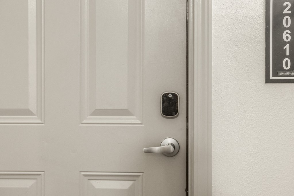 a white door with a black door handle and a white wall with a door number at The Avenue at Polaris Apartments, Columbus, OH