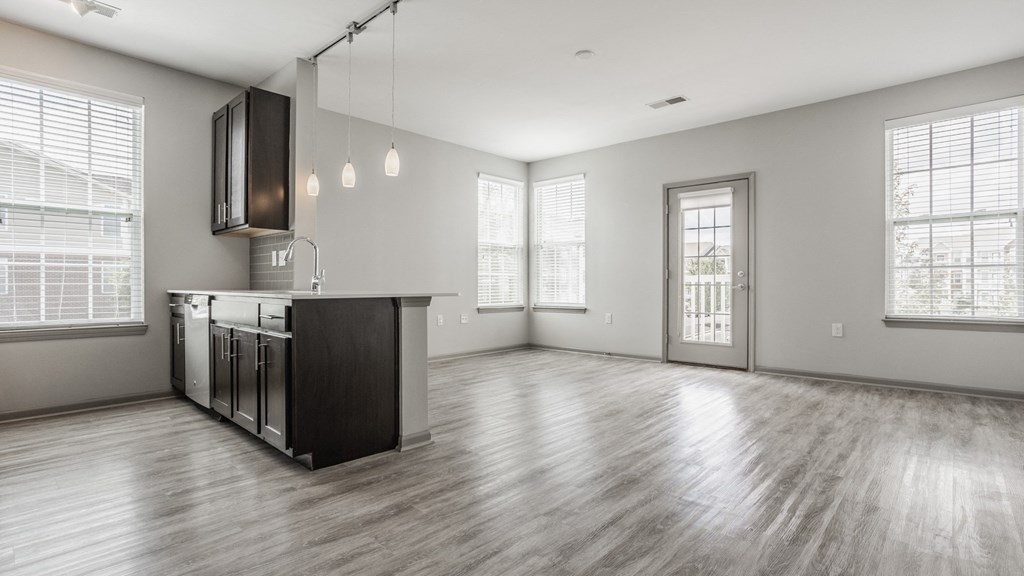 the living room and kitchen of an empty house with a large window at The Avenue at Polaris Apartments, Columbus, OH