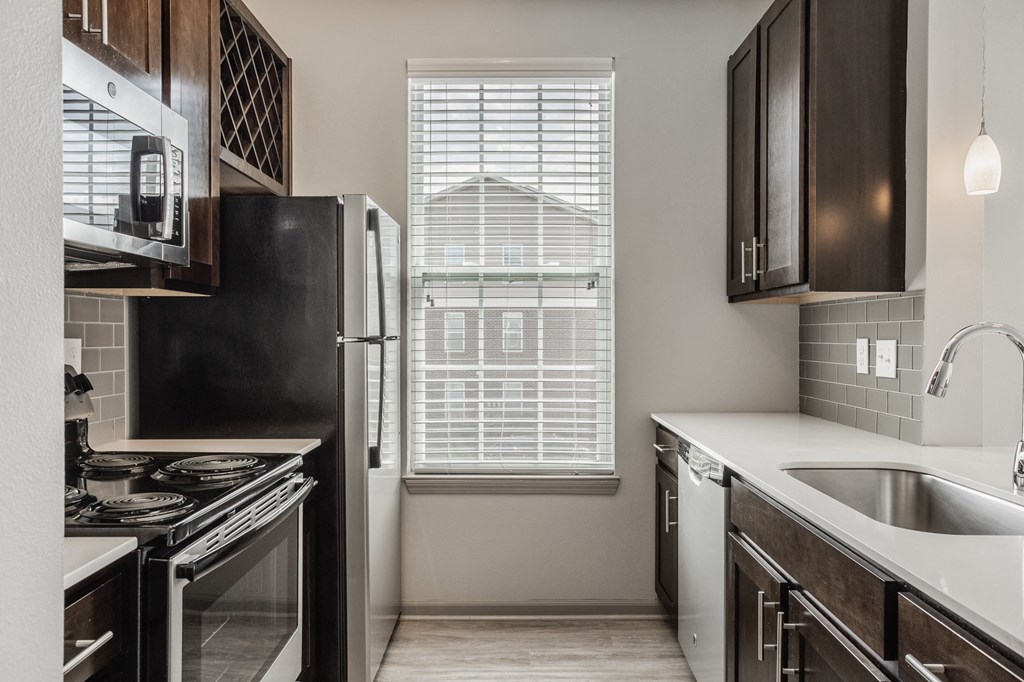 an empty kitchen with a window and a sink and refrigerator at The Avenue at Polaris Apartments, Columbus, OH