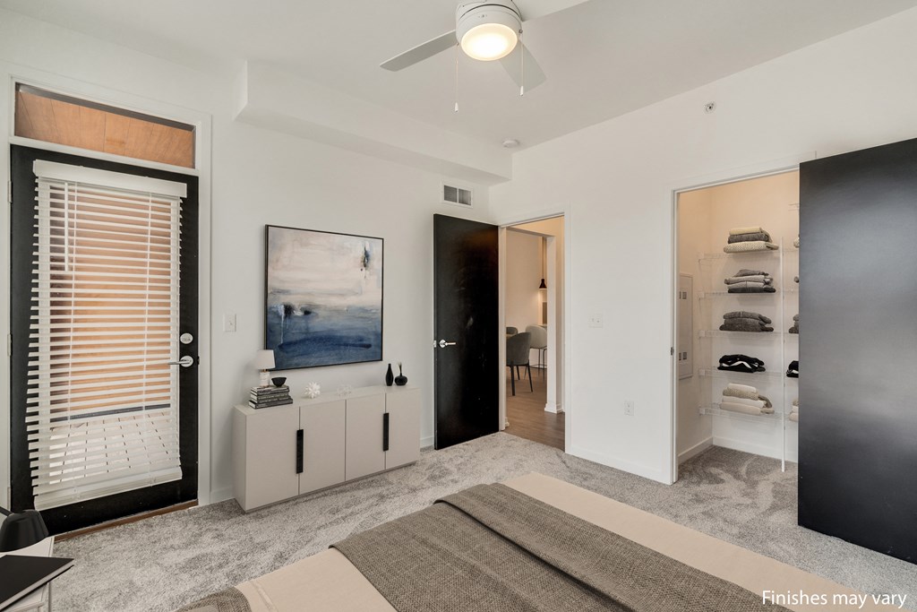 a bedroom with a bed and a ceiling fan  at Uptown Square Apartments, Michigan, 48083