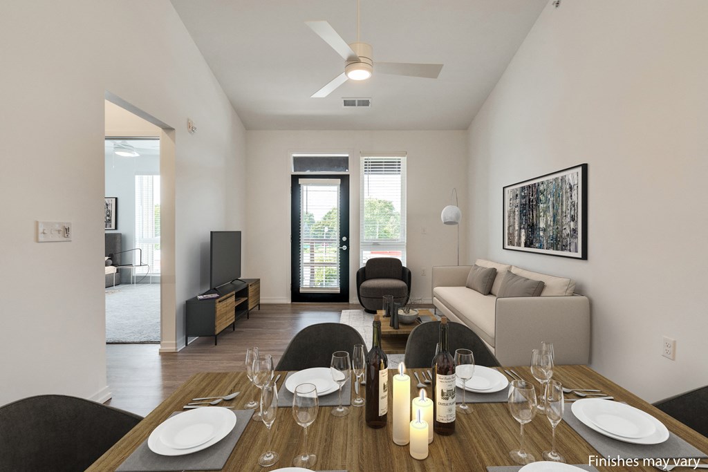 a dining area with a wooden table and chairs and a living room with a couch and a  at Uptown Square Apartments, Michigan, 48083