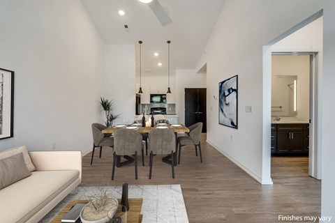 a dining area with a table and chairs and a kitchen in the background a dining area with a table and chairs and a kitchen in the background at Uptown Square Apartments, Michigan
