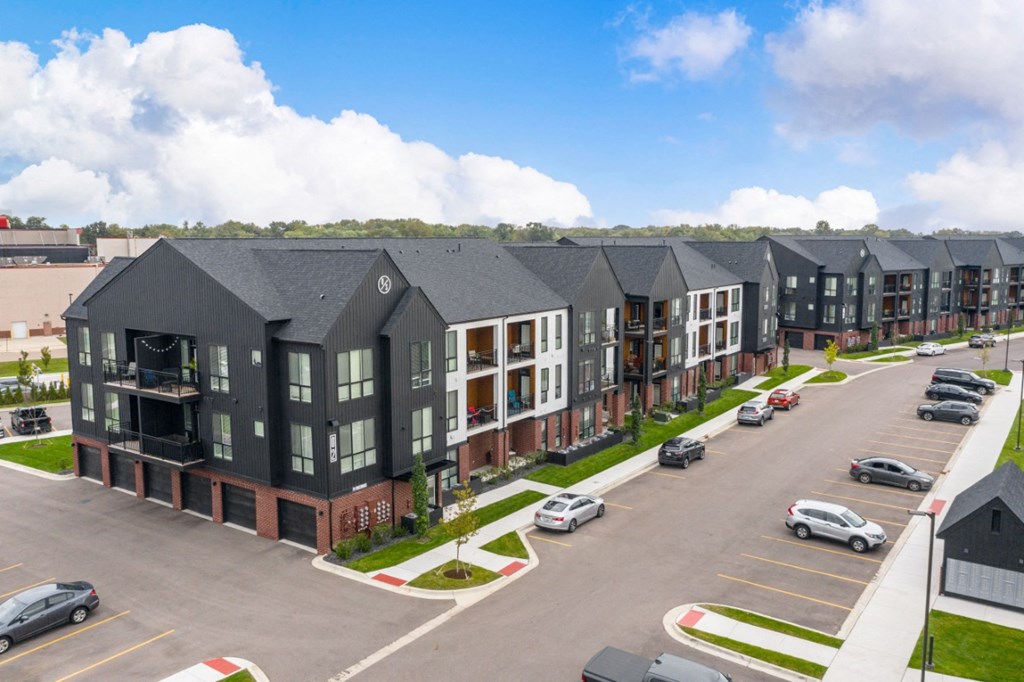 an aerial view of a row of apartment buildings in a parking lot at Uptown Square Apartments, Michigan, 48083