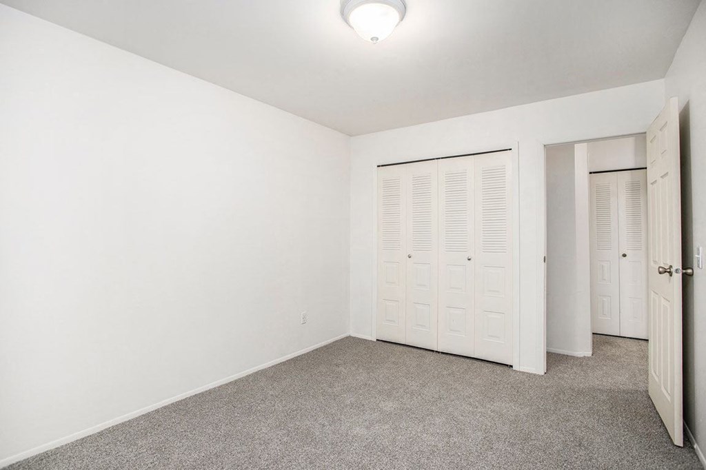 an empty bedroom with a large closet at Fairlane Apartments in Springfield, MI