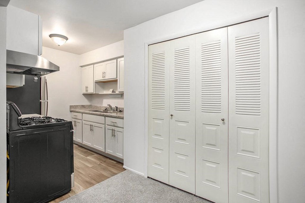 upgraded kitchen with white cabinets and a stove and a refrigerator at Fairlane Apartments in Springfield, MI