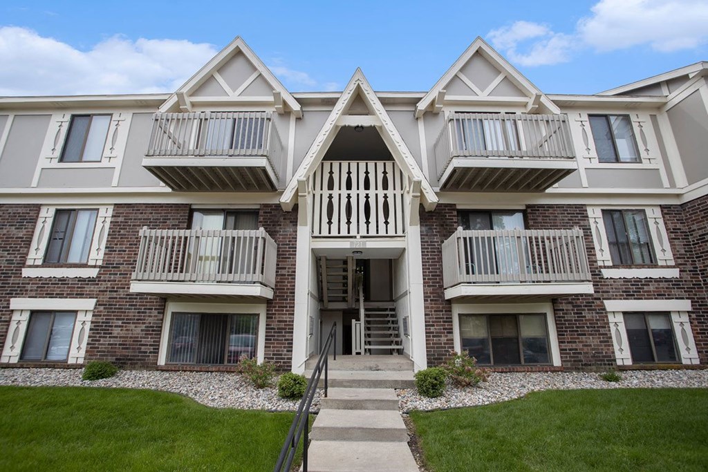 Exterior brick apartment building with balconies and grass at Fairlane Apartments in Springfield, MI