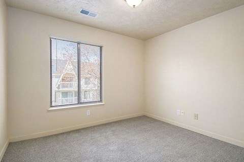 bedroom with a large window and carpeting at Old Farm Apartments, Elkhart, Indiana