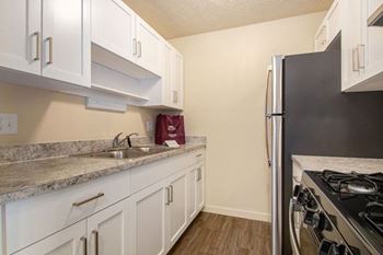 Kitchen with Stainless Steel Appliances and Shaker-style Cabinets at Old Farm Apartments in Elkhart, IN