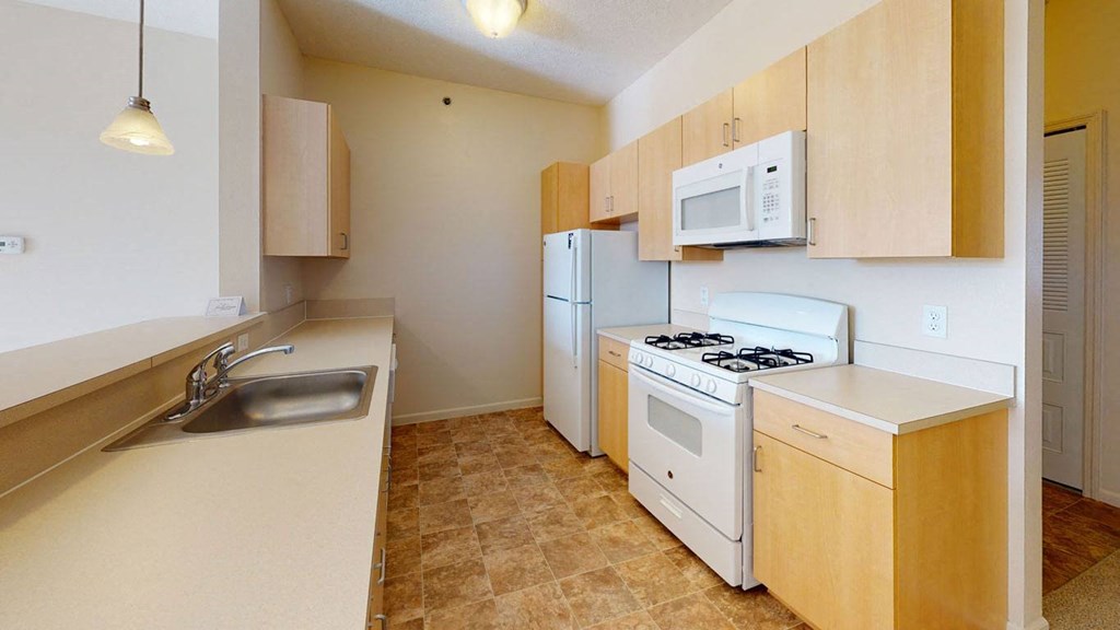 Two bedroom kitchen layout with a stove microwave and dishwasher at Fieldstream Apartment Homes, Iowa