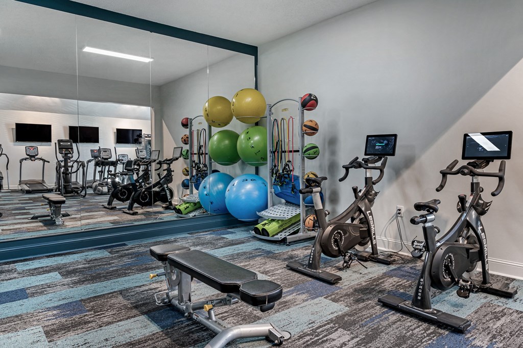 a gym with exercise equipment and mirror at Latitudes Apartments, Indianapolis, 46237