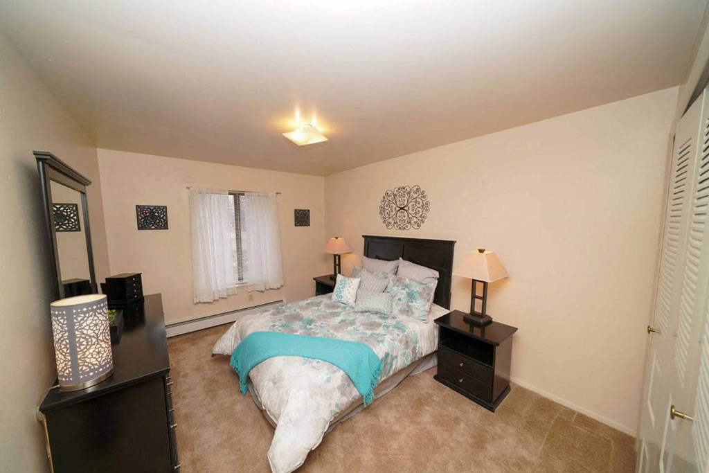 a spacious bedroom with a window at Glen Oaks Apartments, Muskegon
