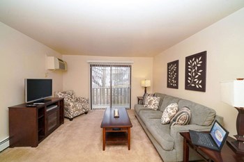 Living Room With Expansive Sliding Glass Doors at Glen Oaks Apartments, Muskegon, MI, 49442 - Photo Gallery 18