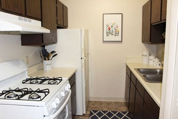 Galley Kitchen with Appliances at Glen Oaks Apartments, Muskegon - Photo Gallery 21
