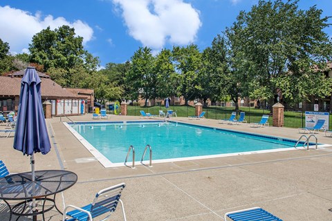 Outdoor swimming pool with lounge chairs at Granada Apartments, Jackson