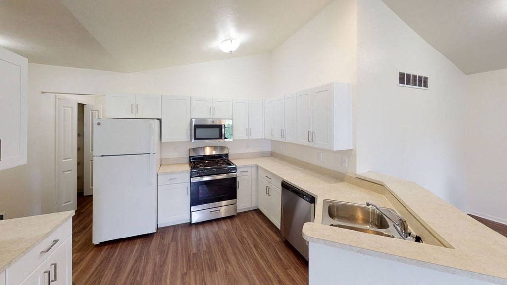 a renovated townhome kitchen with white cabinets and stainless steel appliances at Gull Prairie/Gull Run Apartments and Townhomes, Michigan, 49048