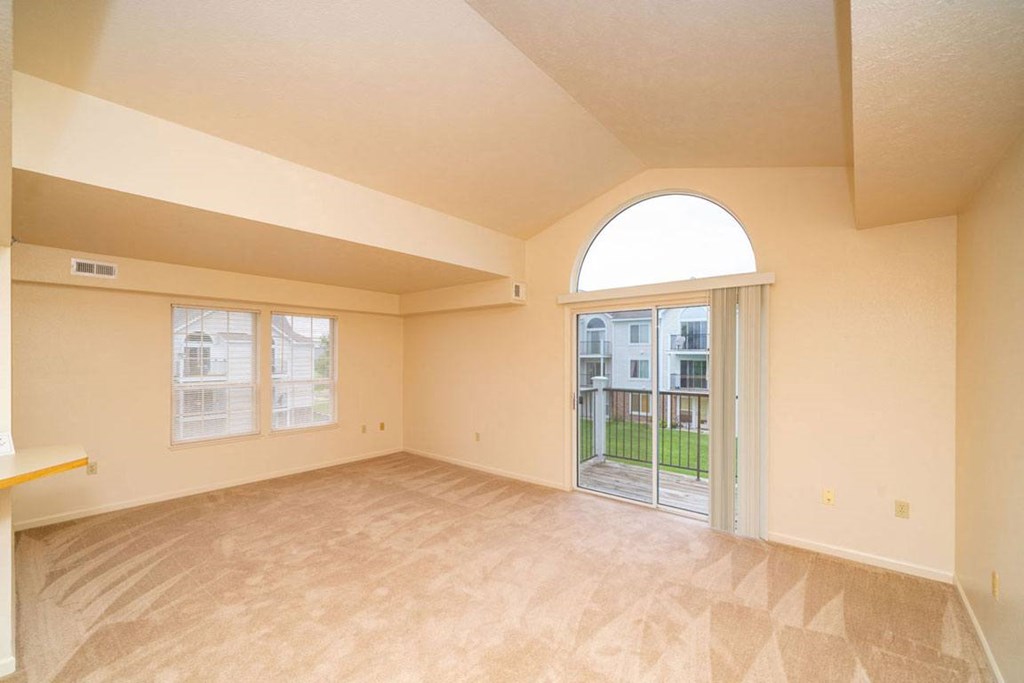 Enlarged living room with a sliding glass door to a balcony at Gull Prairie/Gull Run Apartments and Townhomes, Michigan