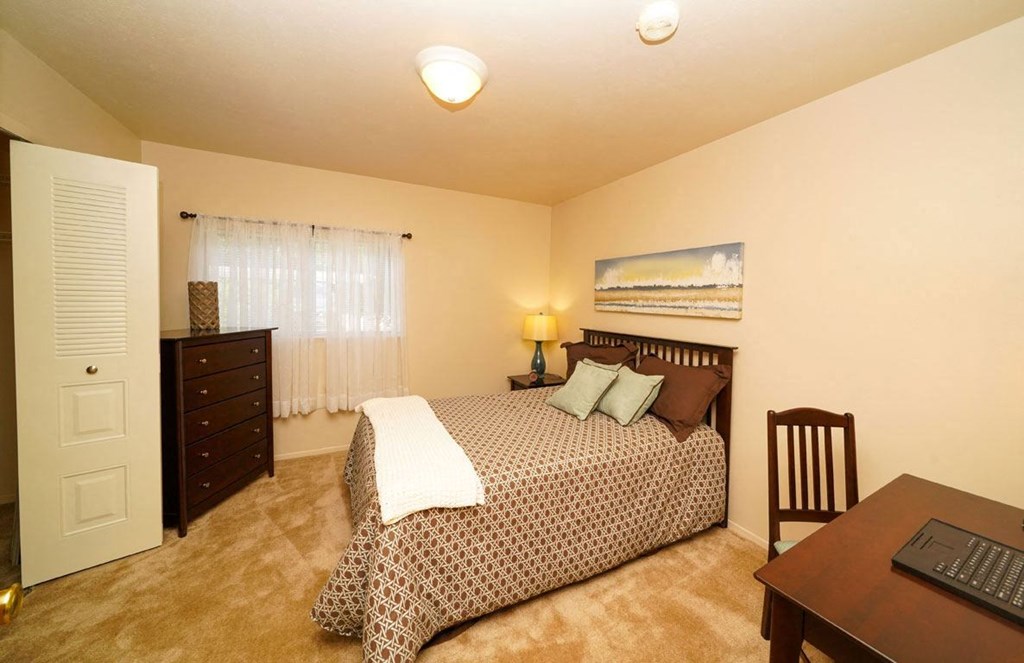 Large bedroom with a window at Glenn Valley Apartments, Battle Creek