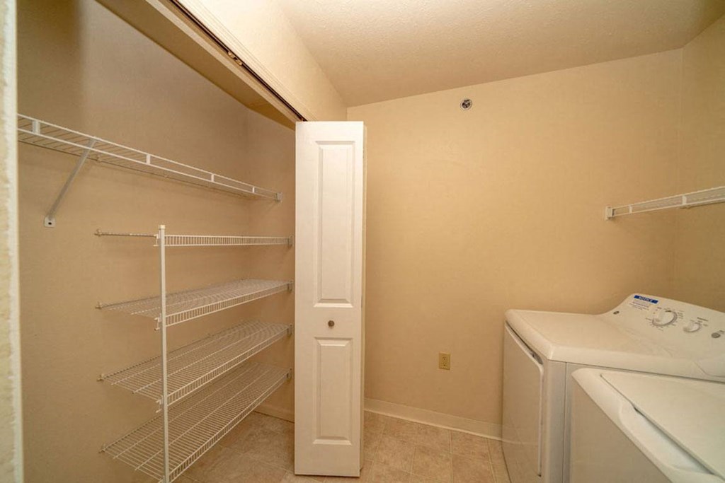 a laundry room with a closet and a washer and dryer at Foxwood and The Hermitage, Portage, MI