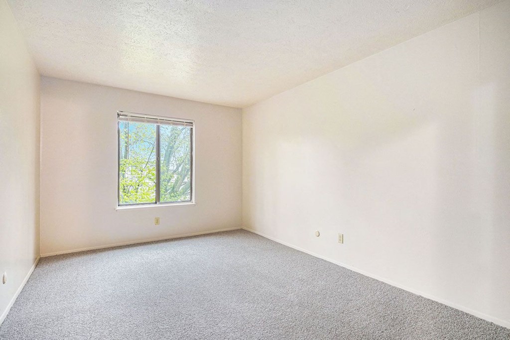 a bedroom with white walls and a window at Hickory Village Apartments, Indiana, 46545