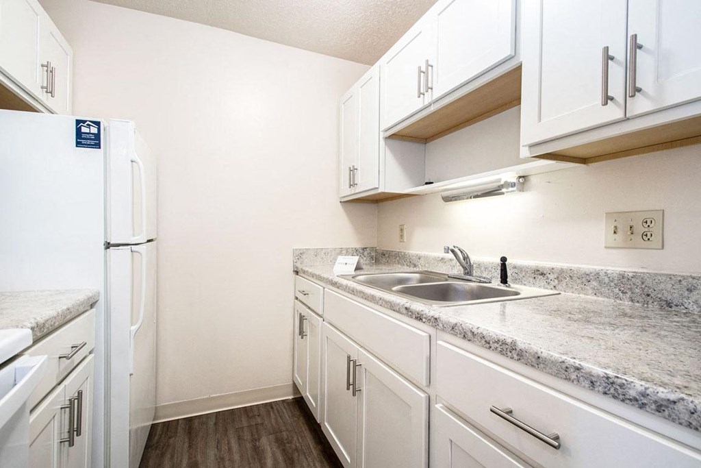 a kitchen with white cabinets and a white refrigerator at Hickory Village Apartments, Indiana, 46545