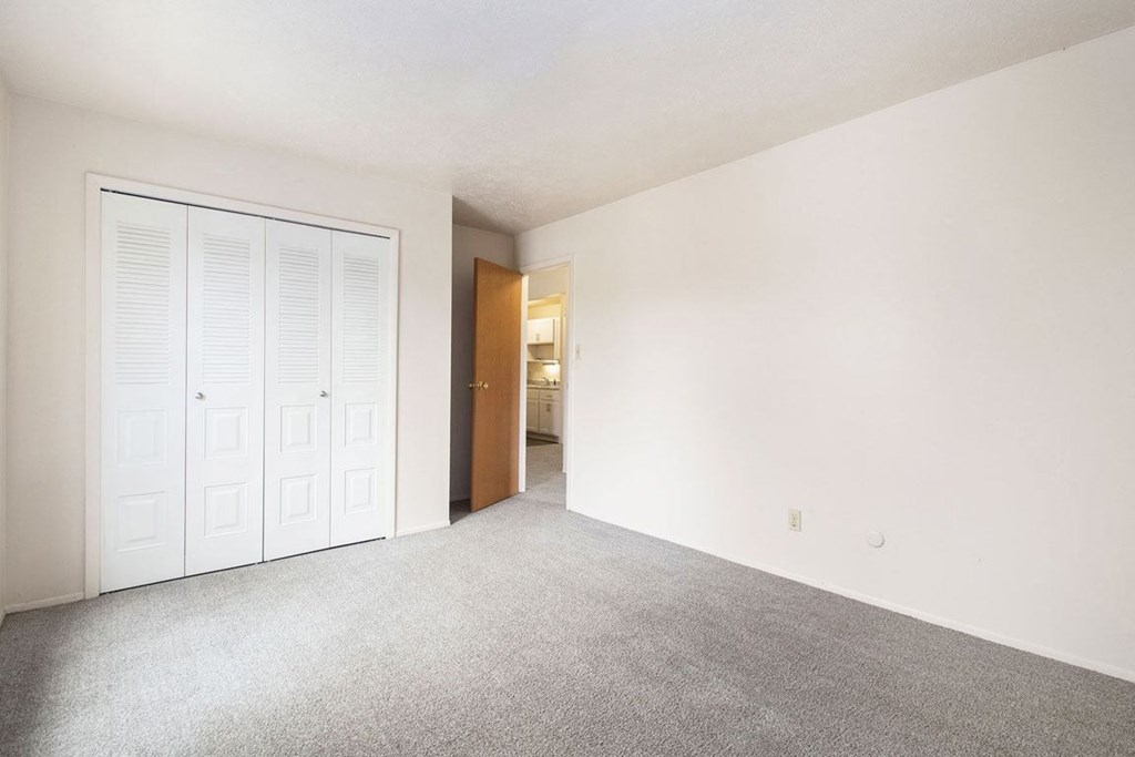 a bedroom with a closet and a door to a bathroom at Hickory Village Apartments, Mishawaka, 46545