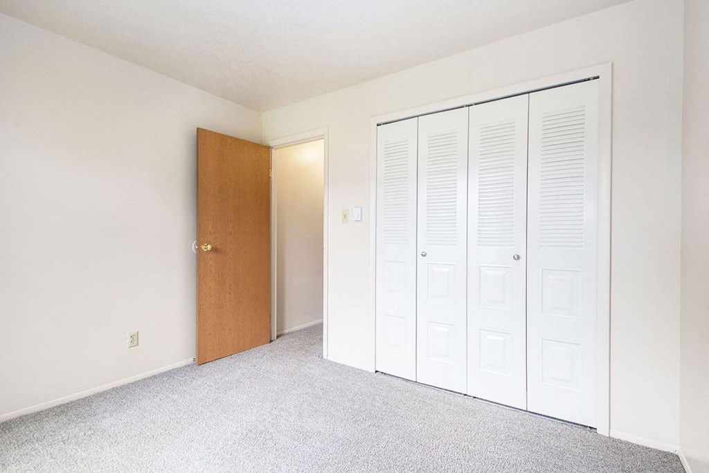 a bedroom with two closets and an open door at Hickory Village Apartments, Mishawaka, IN, 46545