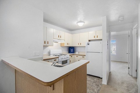 a kitchen with white cabinets and a white refrigerator