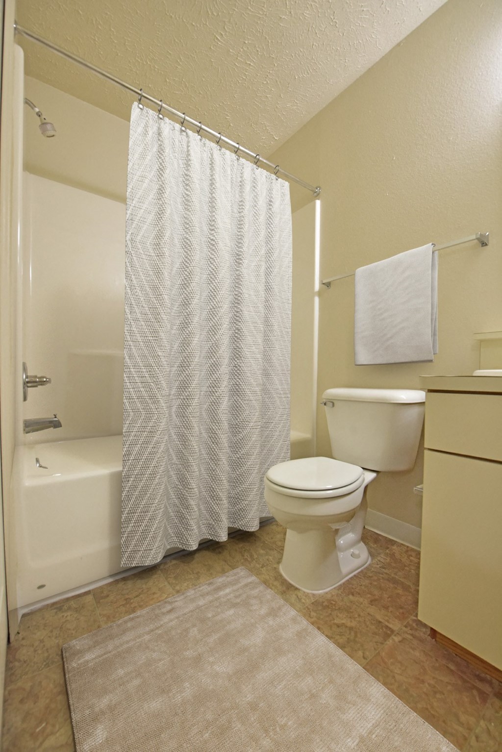 a bathroom with a toilet and a tub and a shower curtain at Heatherwood Apartments, Grand Blanc