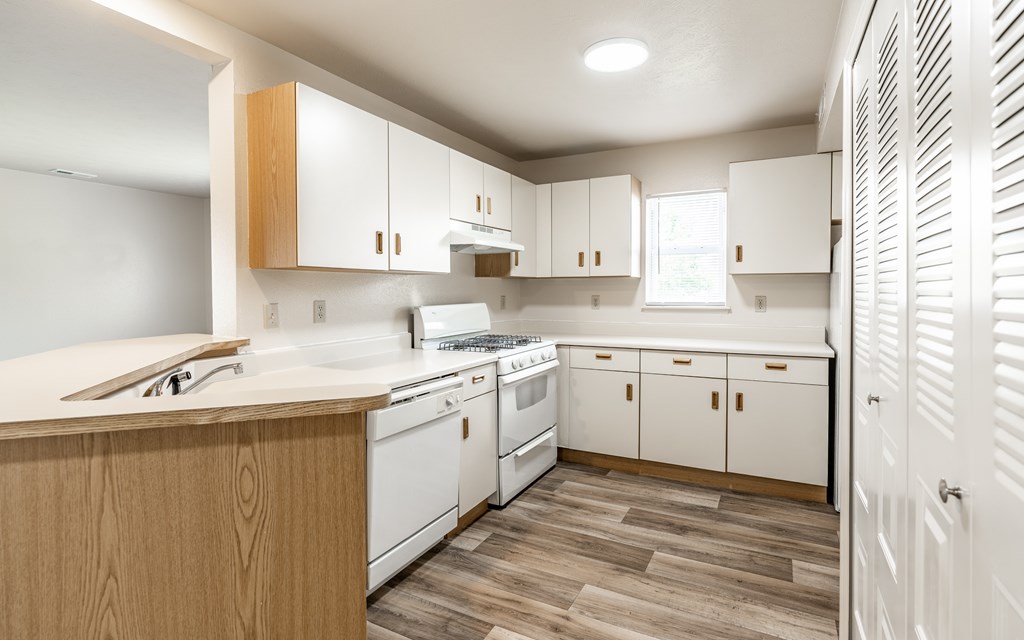 A kitchen with white appliances and wooden cabinets