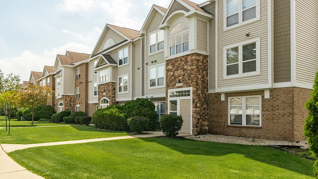 A row of houses with a green lawn in front