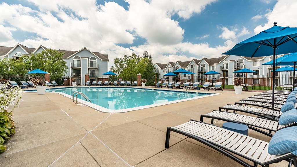 A pool surrounded by sun loungers and umbrellas