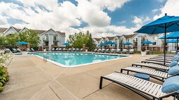 A pool surrounded by sun loungers and umbrellas.