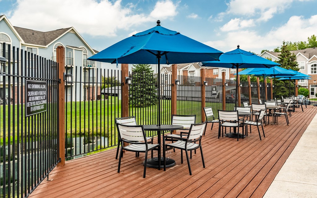 A wooden deck with chairs and umbrellas