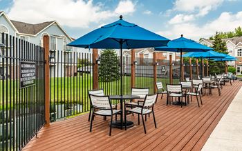 A wooden deck with chairs and umbrellas.
