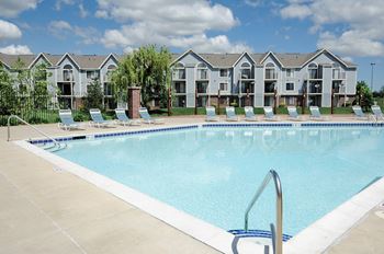 A swimming pool in front of apartment buildings.
