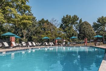 a swimming pool with chairs and umbrellas at the resort at Polo Run Apartments, Indiana