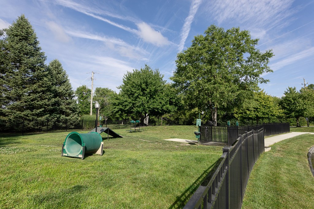 a park with green grass and trees and a black fence at Latitudes Apartments, Indianapolis, IN, 46237