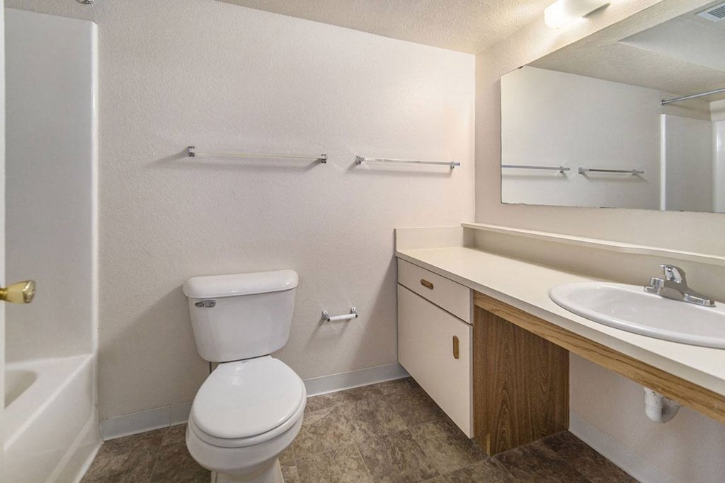 a bathroom with a toilet sink and a mirror at Indian Lakes Apartments, Mishawaka, IN