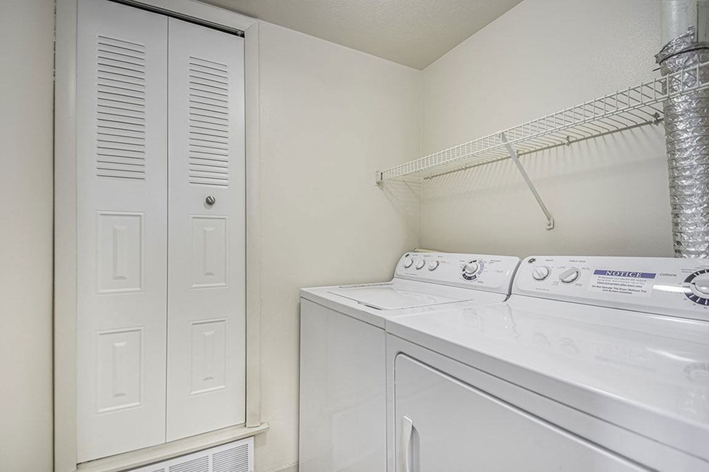 a white laundry room with a washer and dryer and a closet at Indian Lakes Apartments, Mishawaka