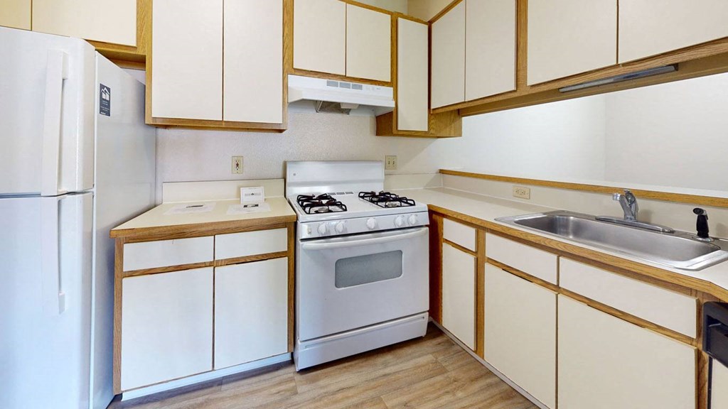 One bedroom seville kitchen with white appliances and breakfast bar at Irish Hills Apartments, South Bend, IN, 46614