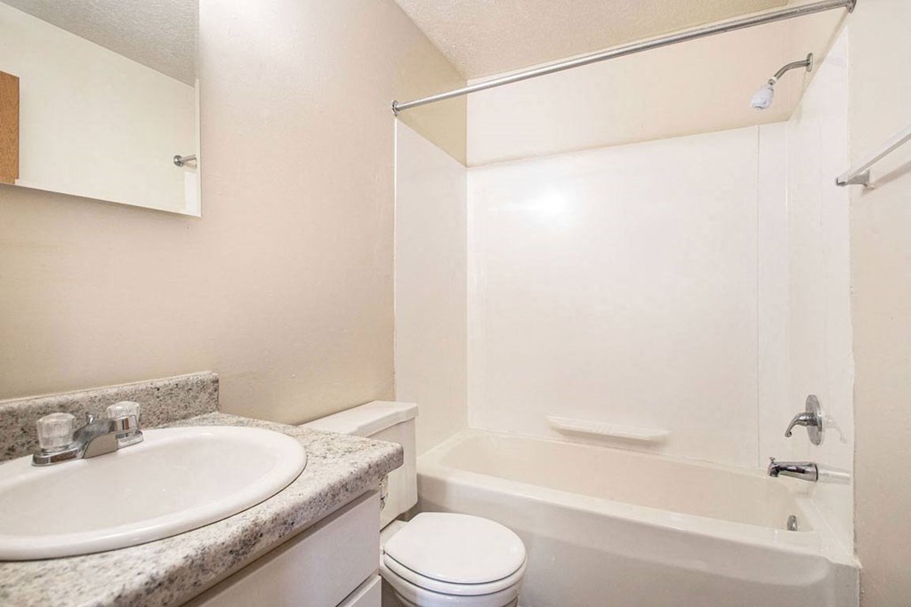 a renovated bathroom with a sink toilet and a bath tub at Irish Hills Apartments, South Bend