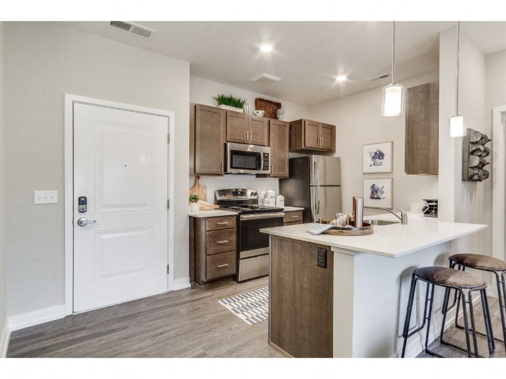 Kitchen with quartz countertops and stainless steel appliances at Montgomery Place Apartments, Montgomery, IL, 60538