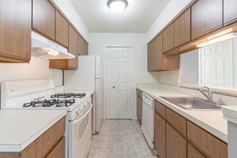 A kitchen with a white stove top oven and a white refrigerator.