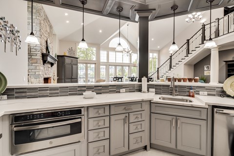 A kitchen with a stone wall and a stove top oven.