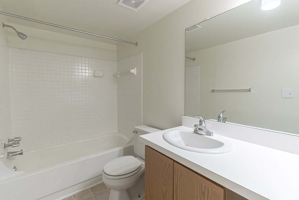 A white bathroom with a toilet, sink, and bathtub.