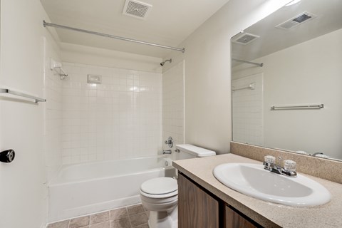 A white bathroom with a toilet, sink, and bathtub.