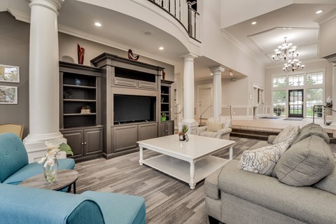 A living room with a blue couch and a white coffee table.
