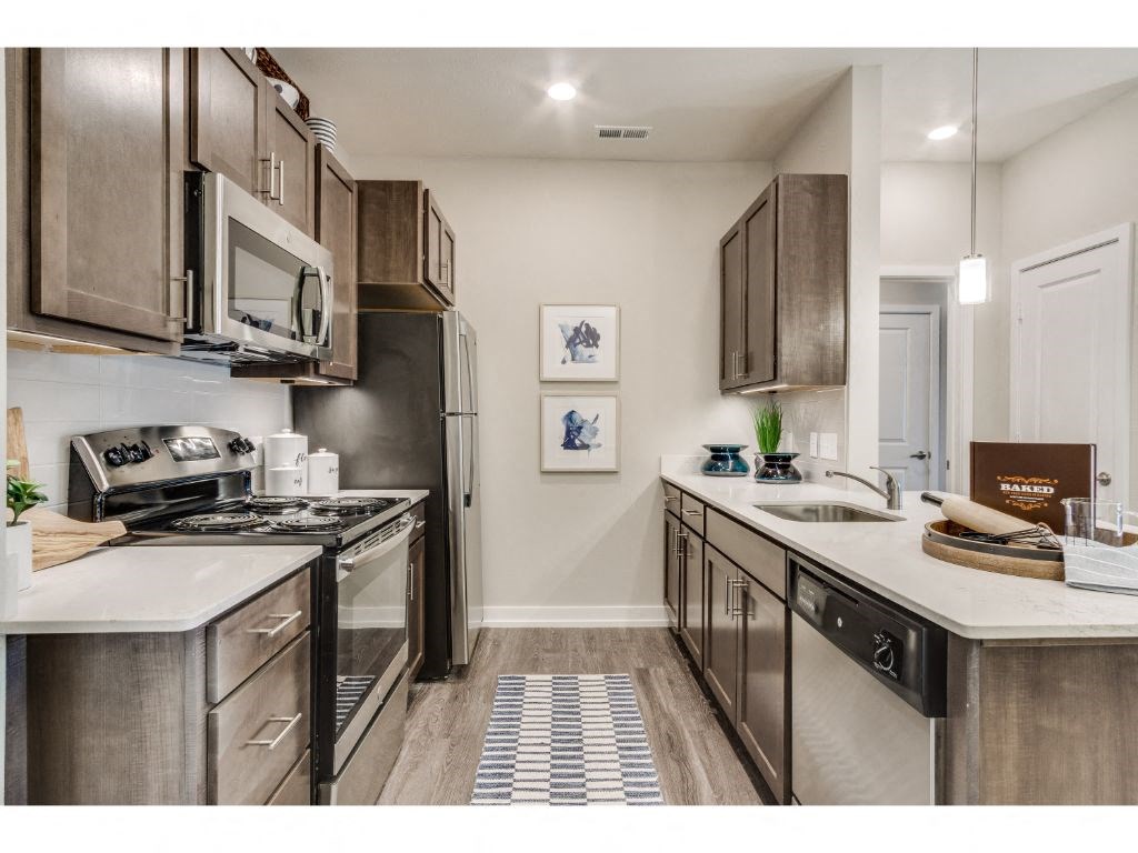 Kitchen with quartz countertops and stainless steel appliances at Montgomery Place Apartments, Montgomery