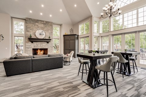 A modern dining room with a stone fireplace and a large table set for six at Westlake Apartments, Michigan